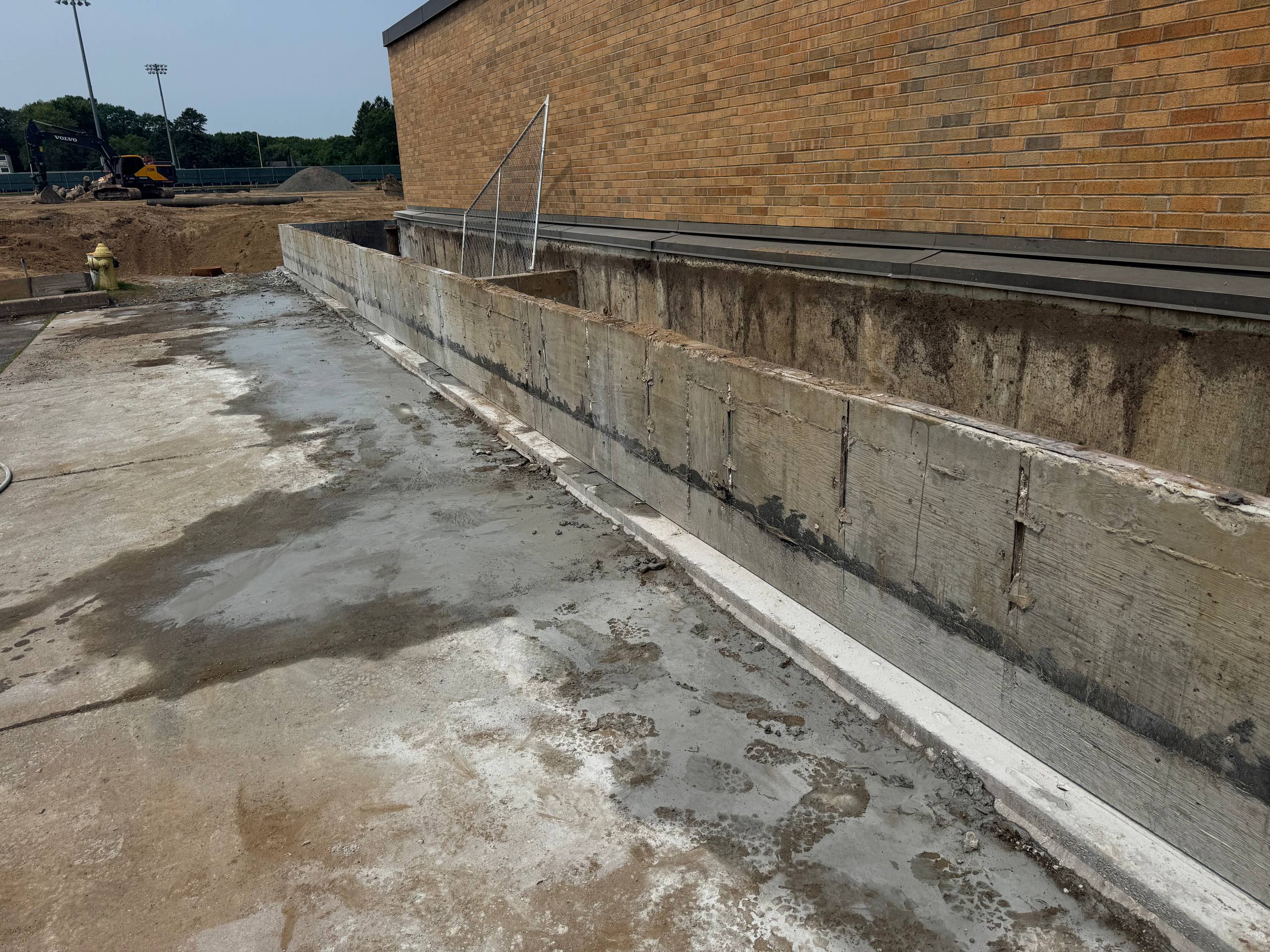 Completed concrete removal along building foundation for waterproofing